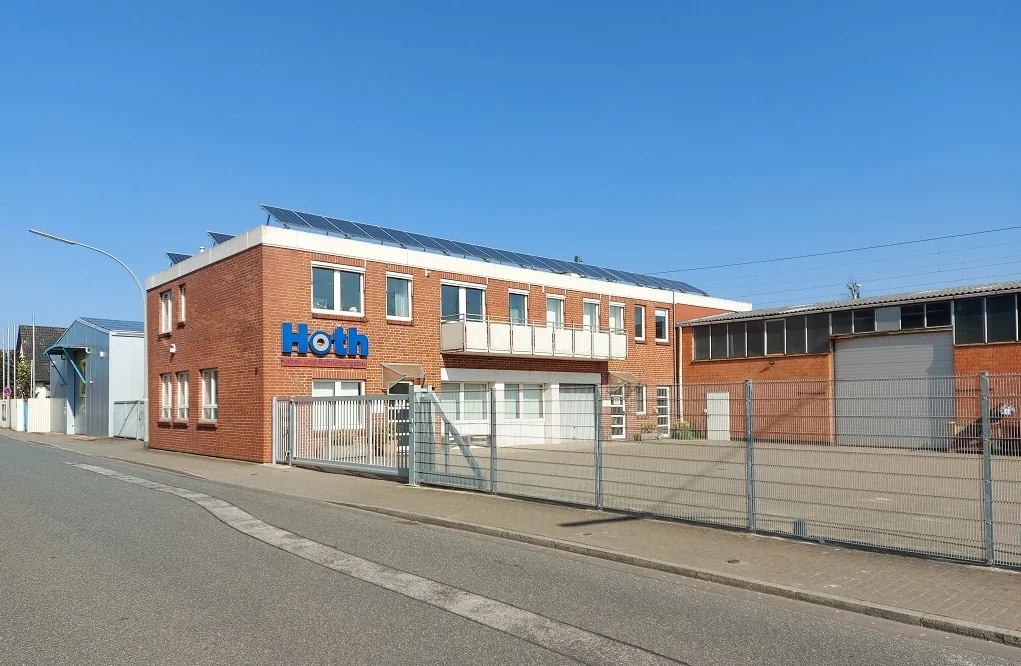 Backsteingebäude des Standorts Bremerhaven mit blauem Hoth-Schriftzug, davor ein Tor
